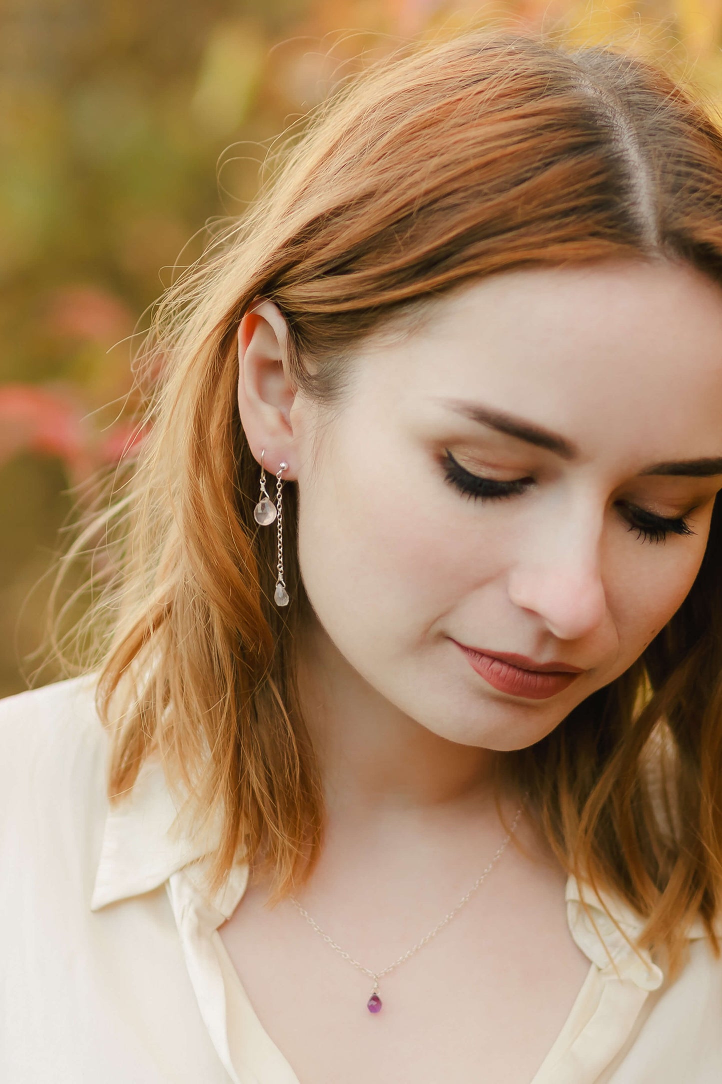 Woman wearing earrings with a blurred natural background