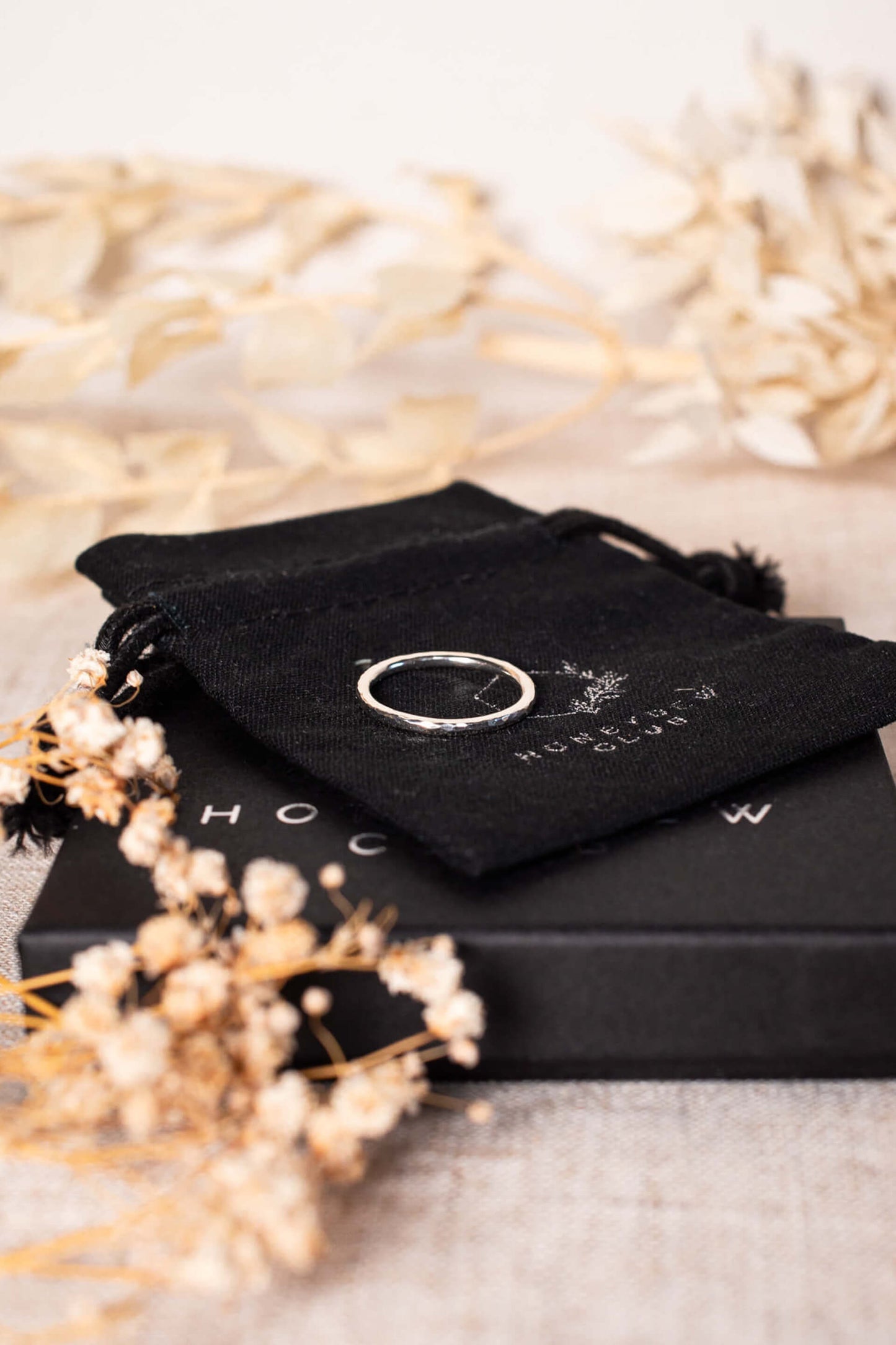 A sterling silver ring band lays on black packaging.