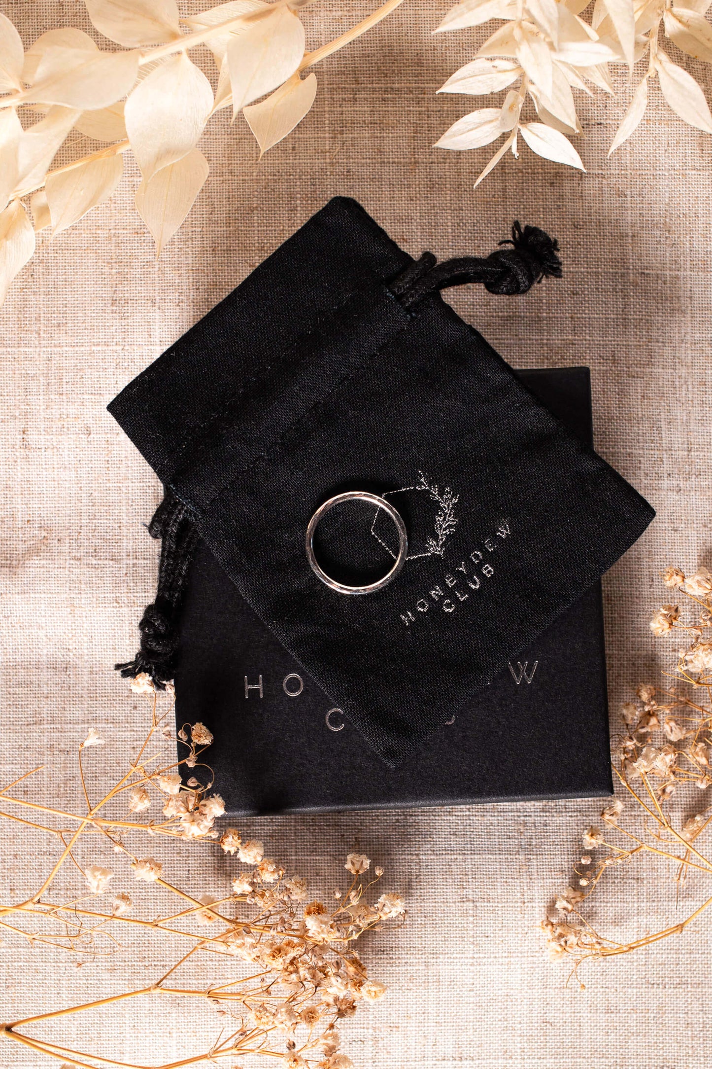 View from above of a sterling silver ring on black packaging.