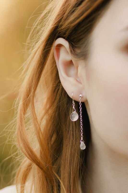 Close-up of a person wearing earrings with a blurred background