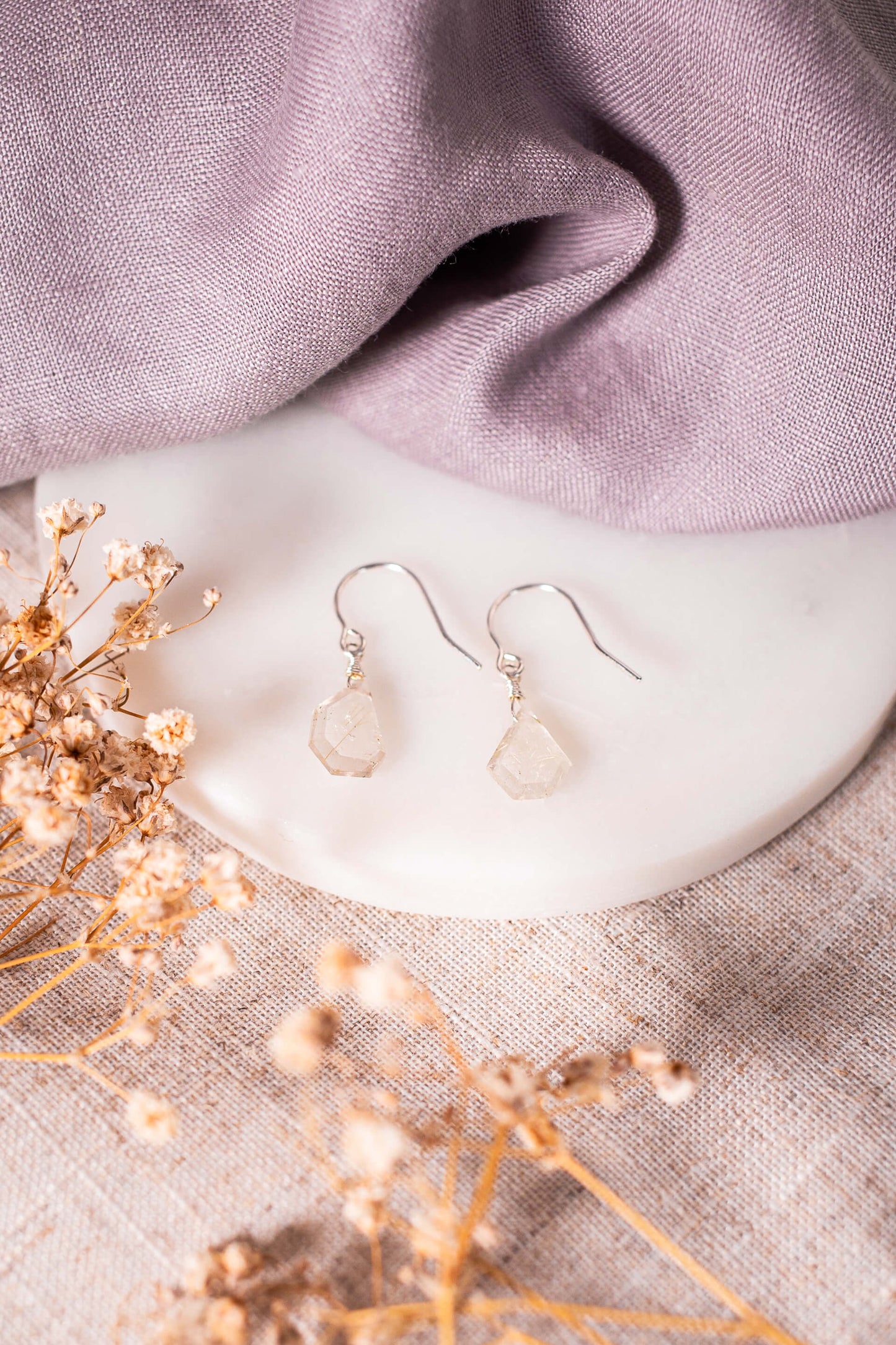 Small, pale yellow gemstones on sterling silver earrings