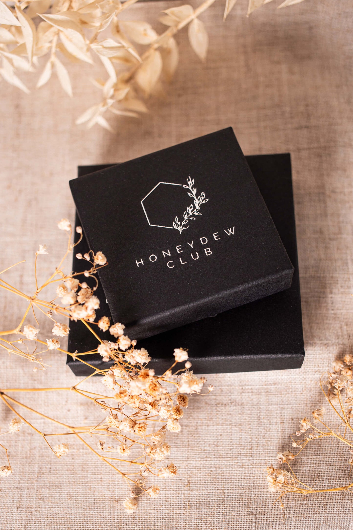 Black gift box for jewellery with a silver foil logo for Honeydew Club
